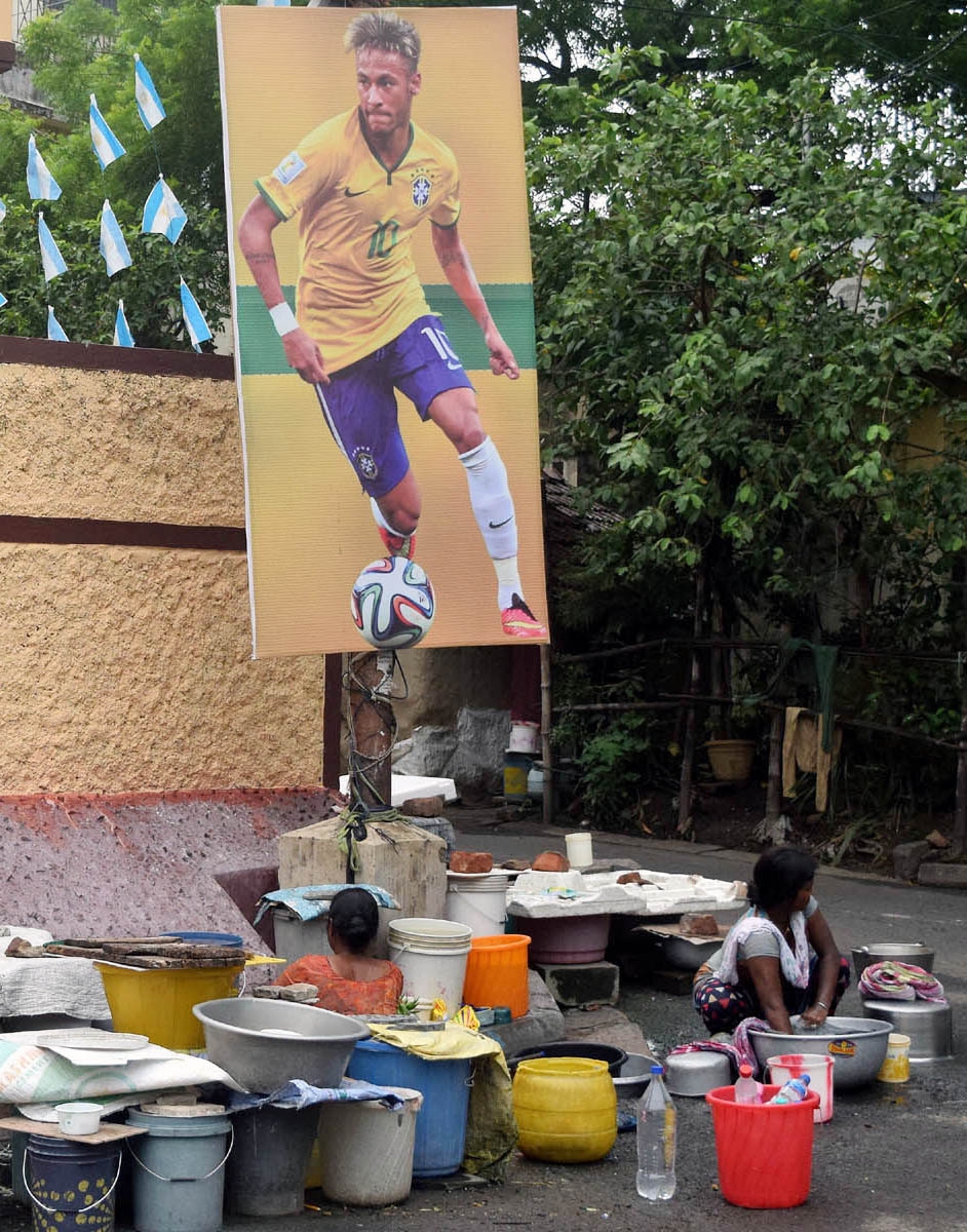 A poster of Brazilian footballer Neymar sticks to a pole near a public tap as FIFA fever grips Kolkata.